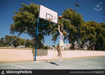 young woman making basketball jump shot
