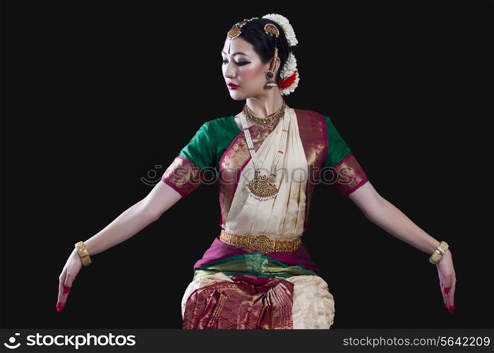 Young woman making Bharatanatyam gesture called Dola-Hastam on black background