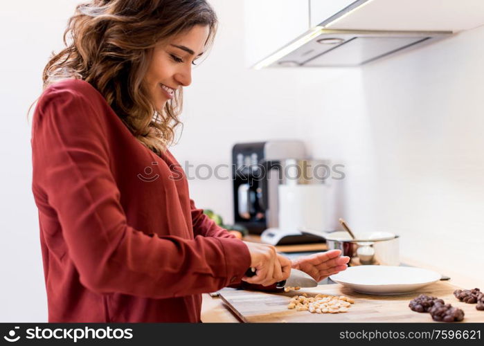 Young woman making chocolate peanut cookies