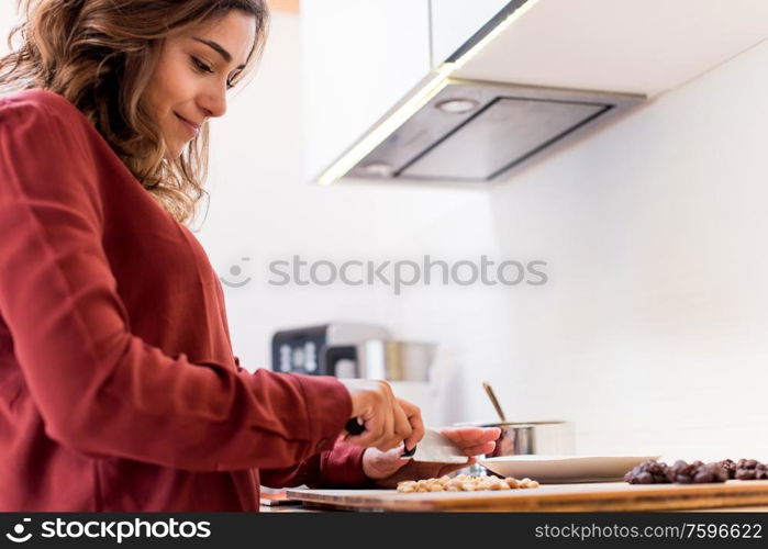 Young woman making chocolate peanut cookies