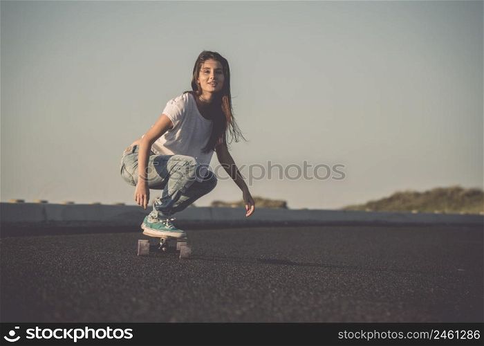 Young woman making downhill with a skateboard