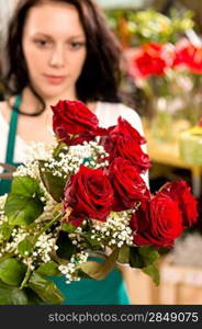 Young woman making flower bouquet florist shop roses selling