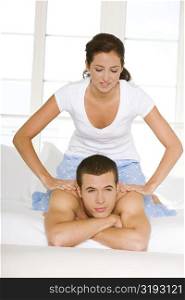 Young woman massaging a young man&acute;s shoulders