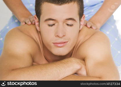 Young woman massaging a young man&acute;s shoulders