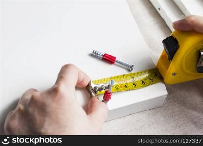 Young woman measuring home furniture with measure tape