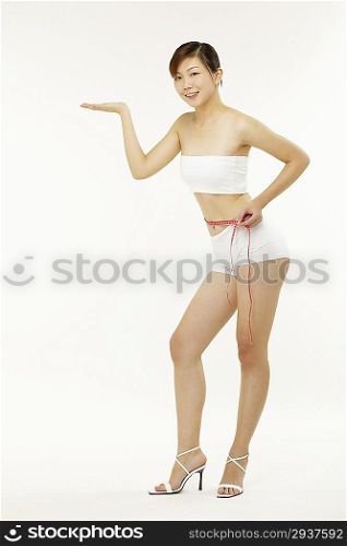 Young woman measuring waistline