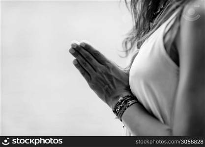 Young woman meditates, practicing yoga in nature. Hands in prayer position.