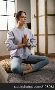 young woman meditating home