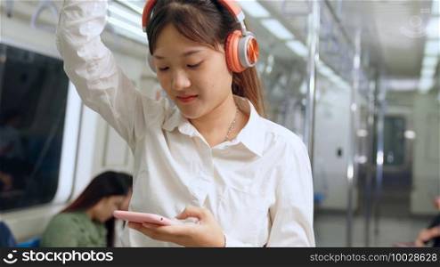 Young woman mobile phone on public train . Urban city lifestyle commuting concept .. Young woman using mobile phone on public train