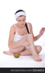 Young woman moisturizing her legs