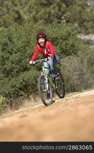 Young Woman Mountain Biking in field