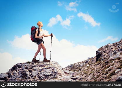 Young woman mountaineer. Pretty young woman tourist standing on top of mountain