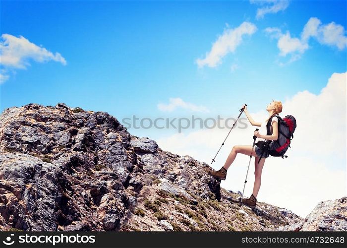 Young woman mountaineer. Pretty young woman tourist standing on top of mountain
