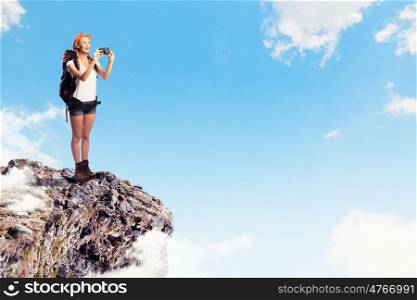 Young woman mountaineer. Pretty young woman tourist standing on top of mountain