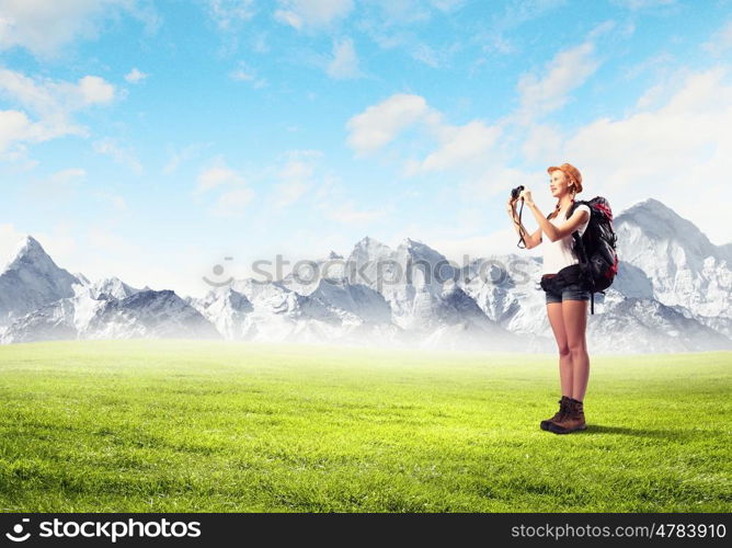 Young woman mountaineer. Pretty young woman tourist standing on top of mountain