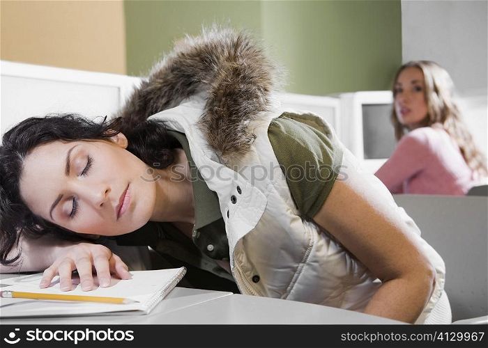 Young woman napping on a desk