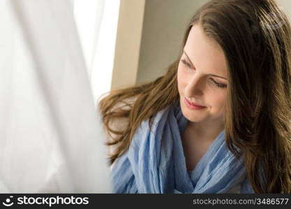 Young woman next to window looking down romantic pure portrait