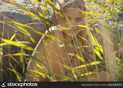 Young woman nude in long grass