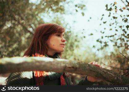 Young woman observes the forest with an old analog camera