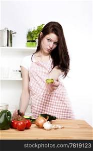 young woman offering chopped cucumber. young woman in kitchen offering a piece of cucumber
