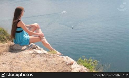 young woman on a rock looking at the sea black sea, Balaklava, Crimea, Ukraine