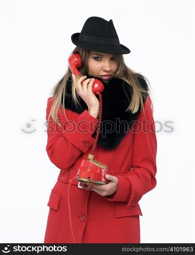 Young woman on an old red phone