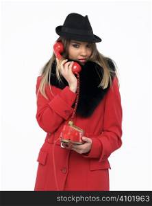 Young woman on an old red phone