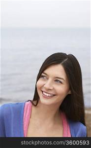 Young woman on beach, smiling