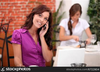 Young woman on cellphone in a restaurant
