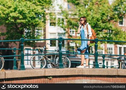 Young woman on european vacation in Amsterdam at the bridge. Happy young woman in european city