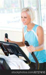 Young woman on fitness machine cardio exercise at sport club