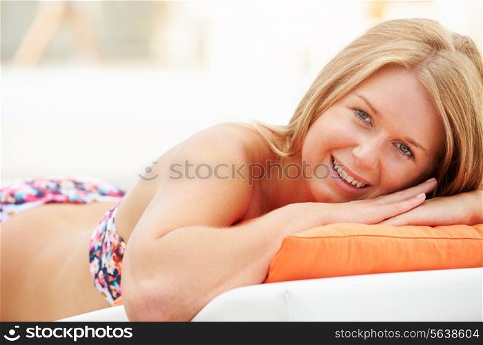 Young Woman On Holiday Relaxing By Swimming Pool
