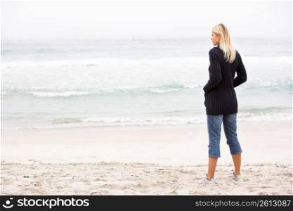 Young Woman On Holiday Standing On Winter Beach