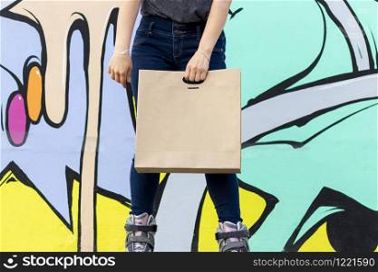 Young woman on roller skates delivering food in paper bag