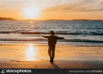 Young woman on spring clothes at the beach during a sunset with copy space