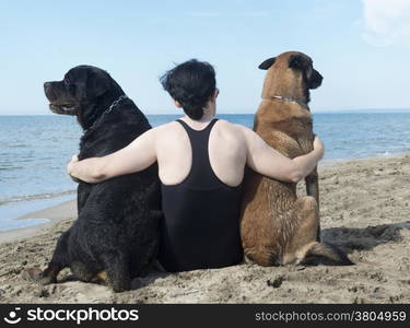 young woman on the beach with her dogs