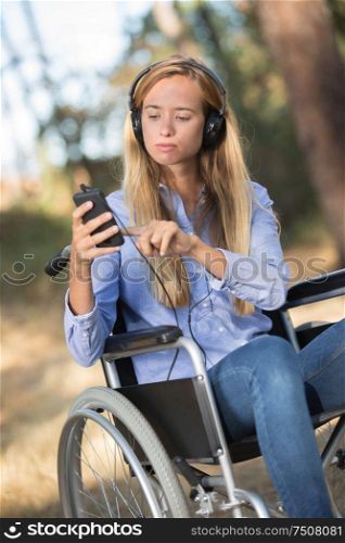 young woman on the wheelchair strolling into the woods