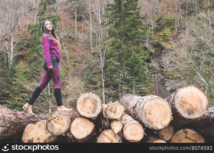 Young woman on wood logs