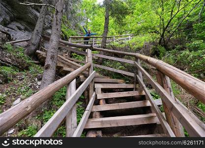 young woman on wooden staircase in mountains