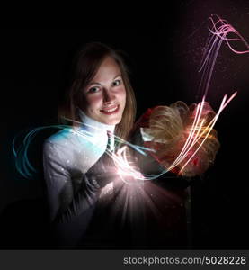 Young woman opening a gift box with shining and glittering lights around her