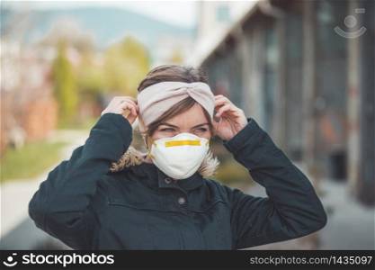 Young woman outdoors putting on face mask. Corona and flu season.