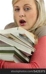 Young woman overworked with a stack of books