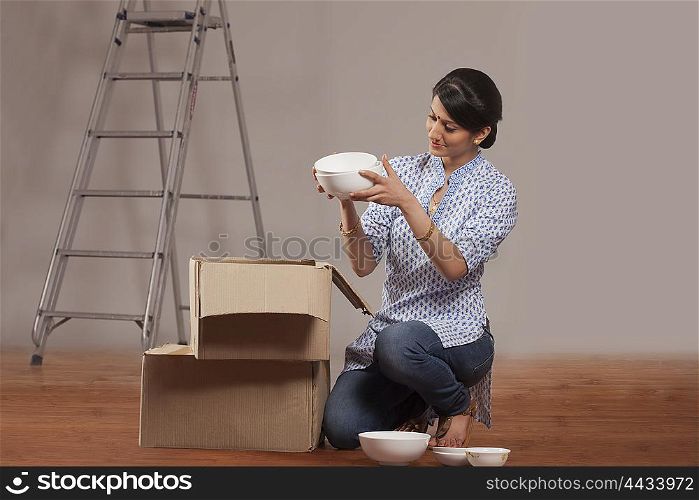 Young woman packing crockery