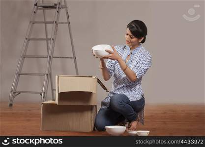 Young woman packing crockery