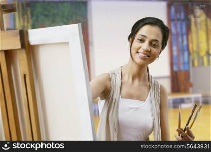 Young woman painting on canvas at home