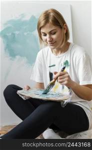 young woman painting with acrylics canvas