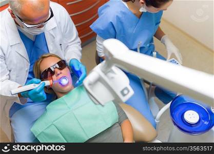 Young woman patient have dental surgery dentist use UV lamp