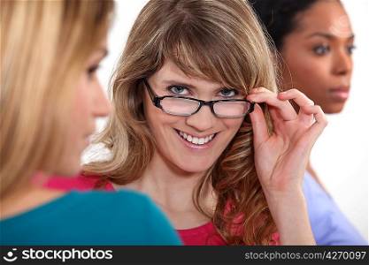 Young woman peering over her glasses