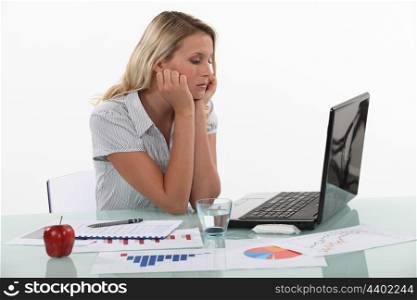 Young woman pensive in front of laptop computer