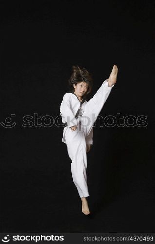 Young woman performing front kick